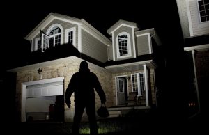 Man in shadow standing in front of house